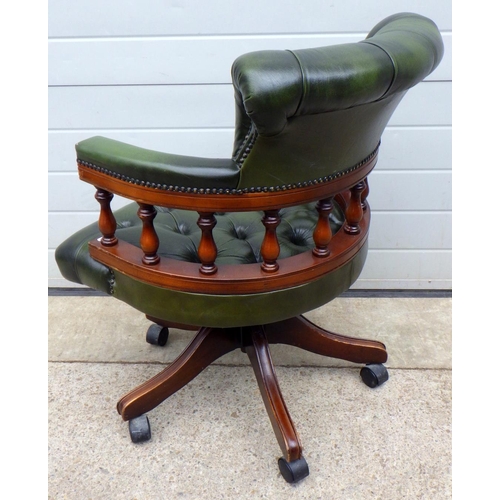 684 - A mahogany button back green leather captains desk chair