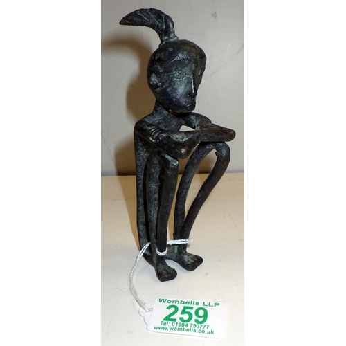 259 - An African stylized figurine, cast bronze. 15cm tall