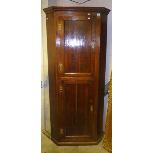 860 - A tall oak corner cupboard