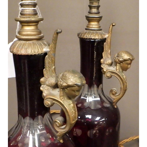155 - A pair of red-flashed-glass bottle-based table lamps with pleated shades.
