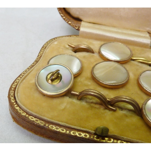 39 - A cased set of six mother of pearl fronted dress waistcoat studs with stone set centres, unmarked ye... 