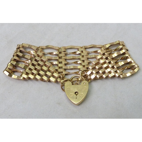 62 - A broad link gate bracelet, 9ct gold.  Approximately 175mm long / 15g