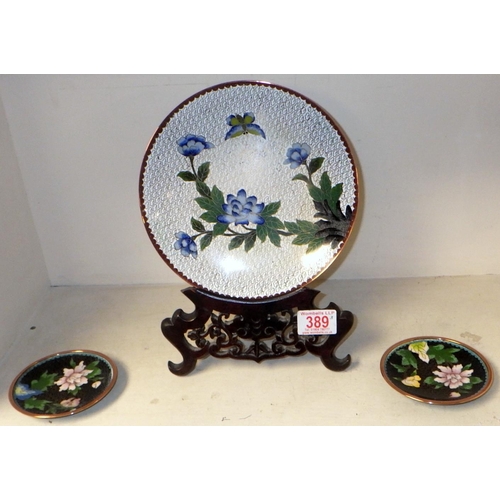 389 - A cloisonne plate on wooden stand together with a pair of small cloisonne dishes (3)