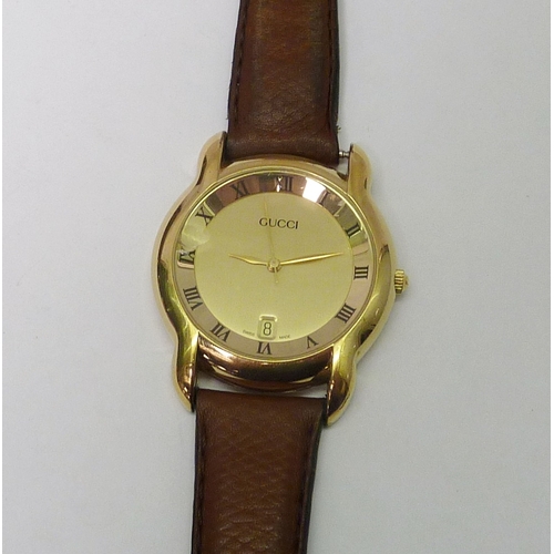 90 - A Gucci 5100M mid-sized wristwatch having a quartz movement in a gold plated case, presented on a Gu... 