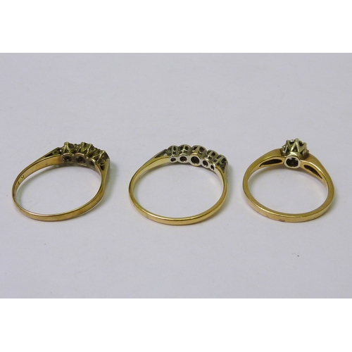 41 - A five stone ring, yellow and white metal marked 18ct; a 9ct gold solitaire ring; a 9ct gold trilogy... 