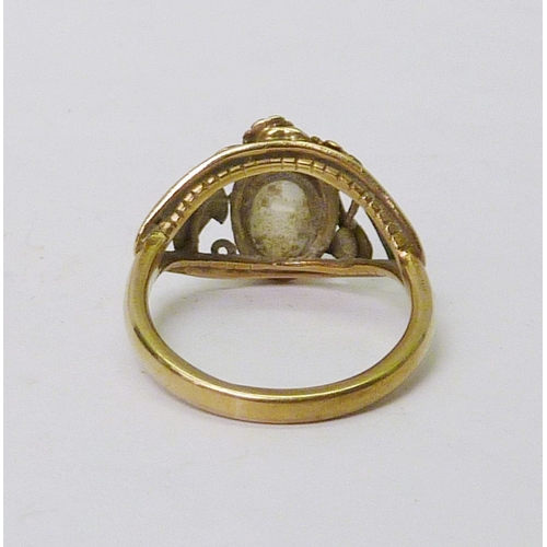 50 - A stone set ring of openwork design, unmarked yellow metal.  Stone 10 x 6mm oval.