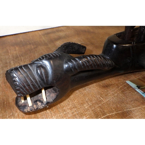 63 - A tribal carved hardwood canoe and figures 66cm long