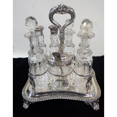 316 - A cruet set, comprising a silver plated stand holding seven cut glass bottles, three having silver l... 