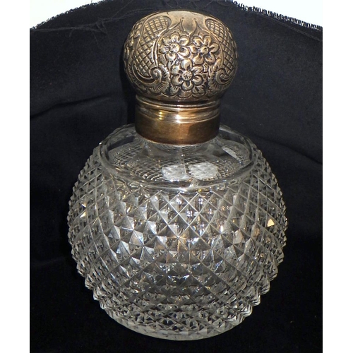 321 - A cut glass scent bottle having a hinged silver lid.  140mm tall.