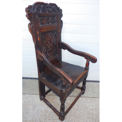 611 - A carved oak panel back chair, repairs, 111cm tall