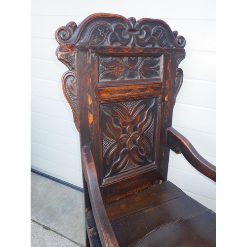 611 - A carved oak panel back chair, repairs, 111cm tall
