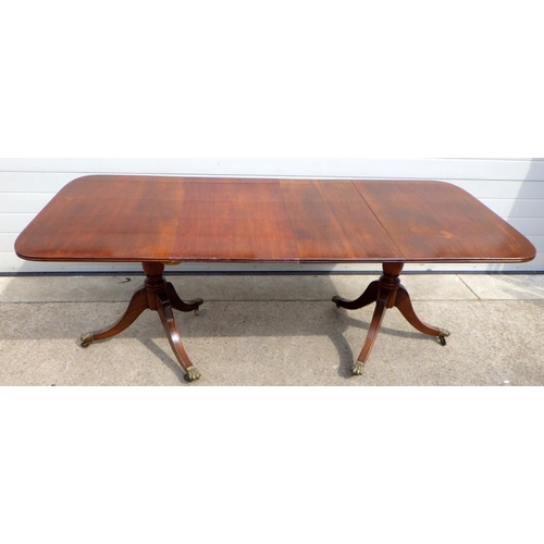 833 - A mahogany twin pillar dining table, with two leaves missing some clips
