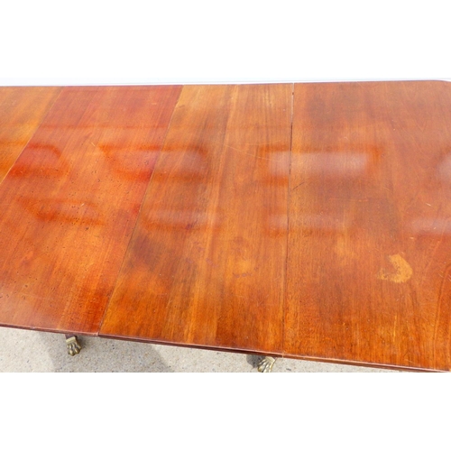833 - A mahogany twin pillar dining table, with two leaves missing some clips