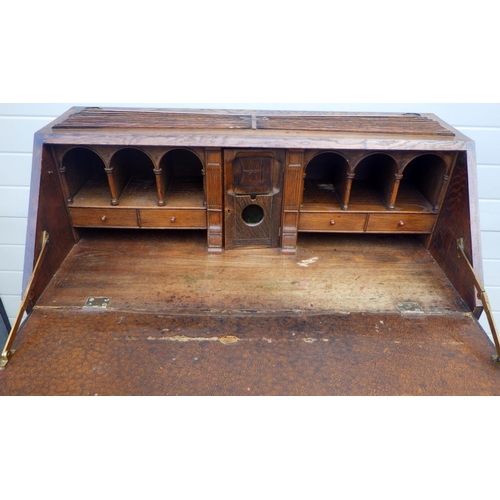 851 - A 1930's oak oak bureau with linenfold decoration, 107cm wide