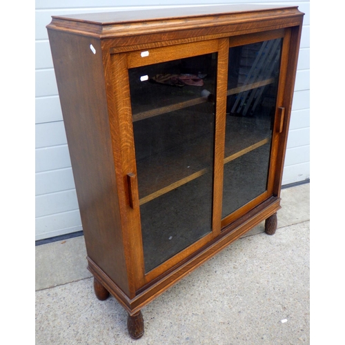 852 - An oak/ply low bookcase with sliding glass doors, 93cm wide