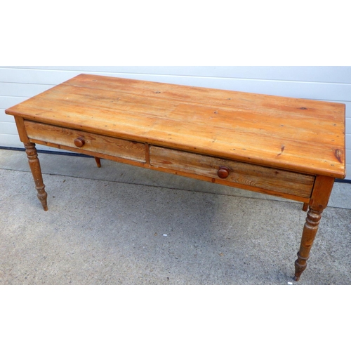 867 - A two drawer pine table on turned legs, 182cm long