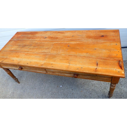 867 - A two drawer pine table on turned legs, 182cm long