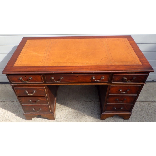 869 - A reproduction mahogany pedestal desk with brown leather inset top, 122cm wide