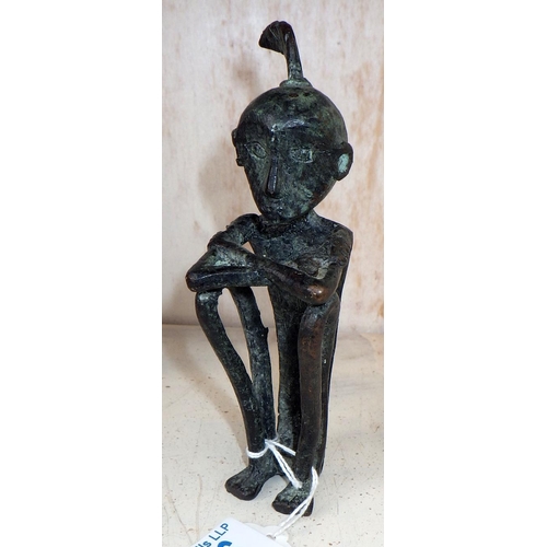 186 - An African stylized figurine, cast bronze. 15cm tall