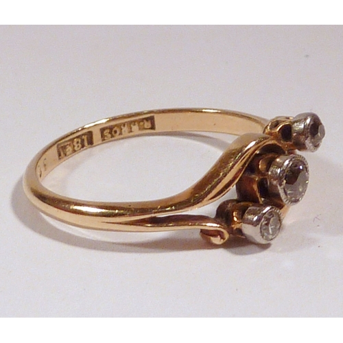 53 - A diamond trilogy twist ring, yellow metal marked 18ct.  Central stone 2.5mm diameter.
