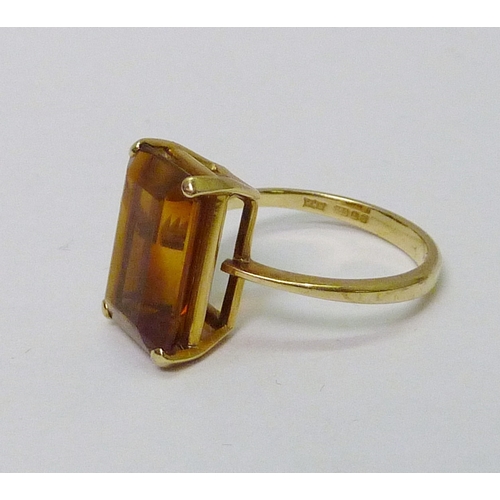76 - An 18ct gold cocktail ring set with a baguette cut golden tone gem stone.  Stone 15 x 8mm / 6g gross