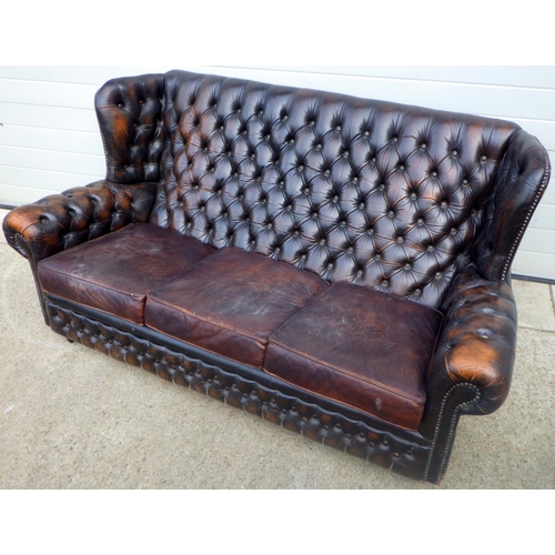 792 - A button back leather settee, later cushions, split arm, damage, 180cm wide