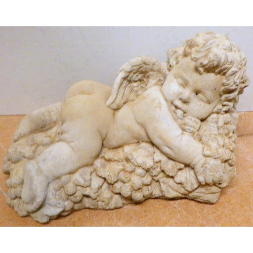 830 - A concrete garden figure of a sleeping cherub, 27cm long