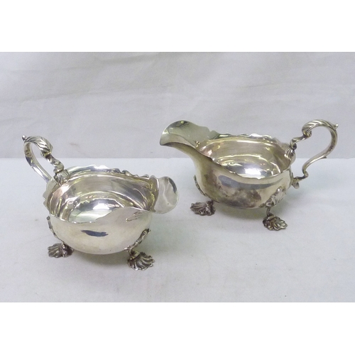 117 - A pair of silver sauce boats standing on shell scroll feet, 20th cent.  Each 184mm long / 640g total