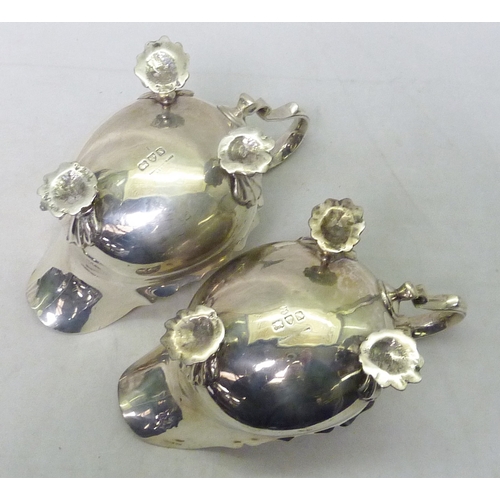 117 - A pair of silver sauce boats standing on shell scroll feet, 20th cent.  Each 184mm long / 640g total