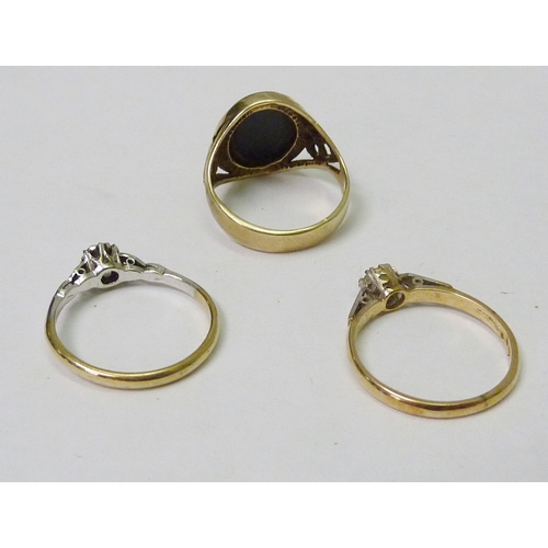 144 - A 9ct gold signet ring 4g gross; a 9ct gold stone set solitaire ring; another solitaire ring, yellow... 