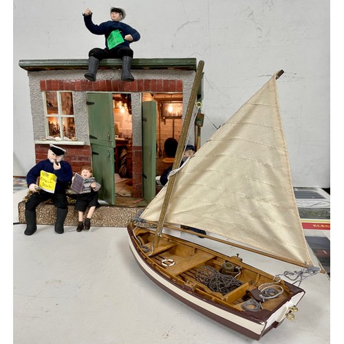 75 - A model of a boat house together with boat & sailor dolls