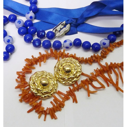 301 - A Chanel spotted glass bead necklace fastening on blue silk ribbons, beads and CC logos 700mm long, ... 