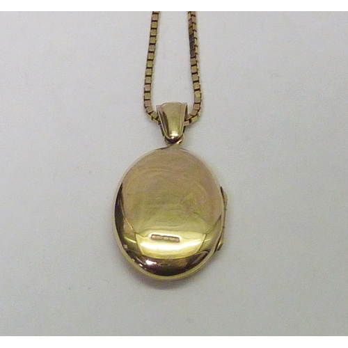 313 - A 9ct gold photo locket set with a single brilliant cut red sapphire, the whole suspended on a 9ct g... 