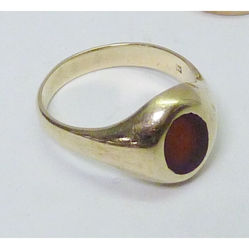 314 - A 9ct gold red stone set signet ring, a/f abraded and setting worn; a 9ct gold band ring. (2)  10g g... 