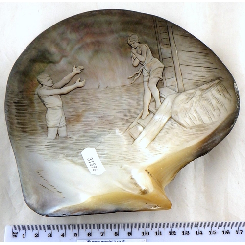 275 - A carved and signed clam shell 19cm x 19cm