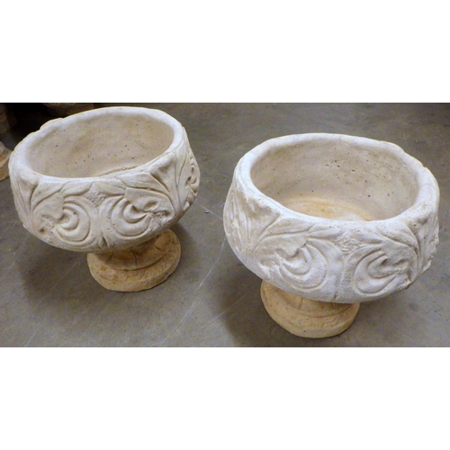 791 - A pair of circular concrete garden urns with patterned side