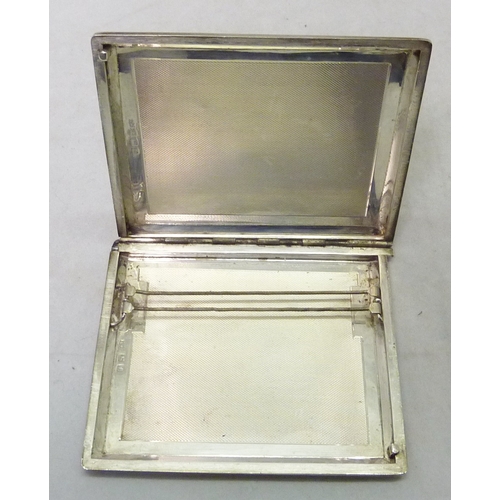 403 - Silver: a sliding action cigarette case having engine turned decoration and engraved 