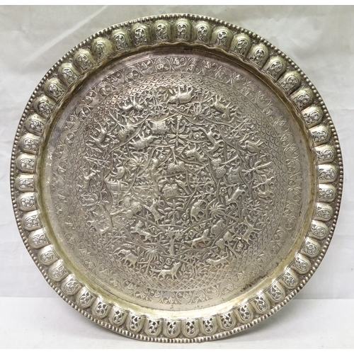 408 - An Indian repousse white metal tray having a radiating landscape design incorporating animal, tree a... 