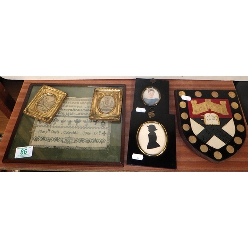 86 - A painted Exeter shield together with a sampler dated 1837, miniature portraits and two brass framed... 
