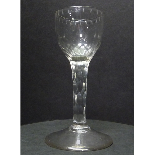 265 - A drinking glass having a facet cut stem and cut decoration to the rim.  c1800.  129mm.