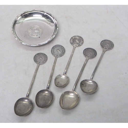 2 - Seven matching nut dishes each set with a central coin, white metal marked Sterling, 75mm diameter; ... 
