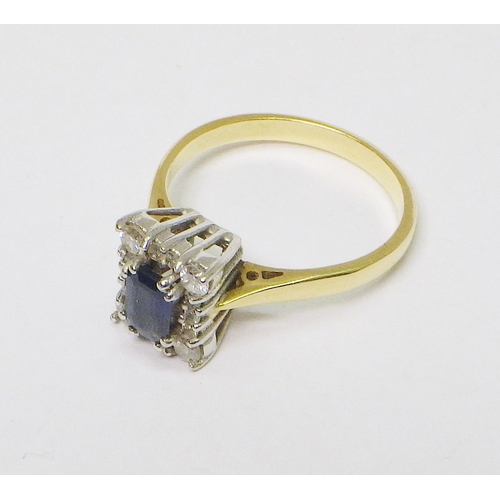 30 - An 18ct gold diamond and sapphire cluster ring comprising 14 brilliant cut diamonds around an emeral... 