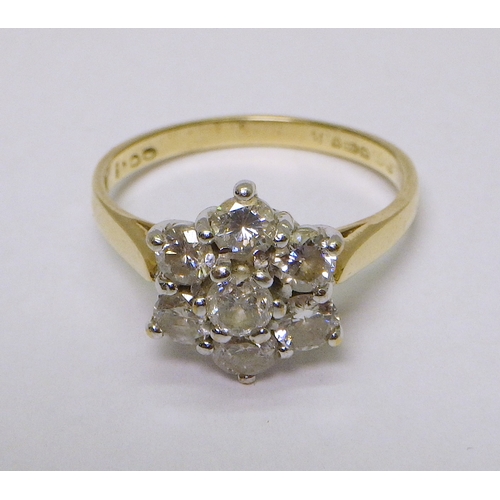 34 - A daisy cluster ring comprising six brilliant cut diamonds in an 18ct gold setting.  Diamonds each a... 