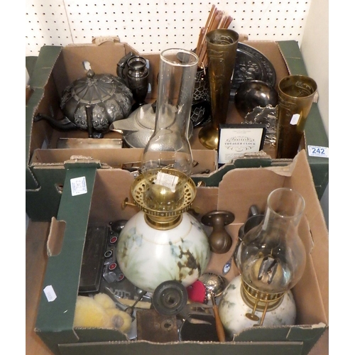 242 - A box of misc metal wares, cutlery, oil lamps etc (2)