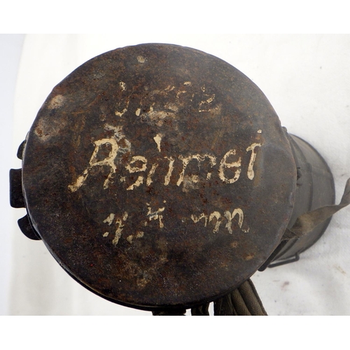 302 - Military interest: a German WW1 gas mask in original canister with soldier's name painted to lid.