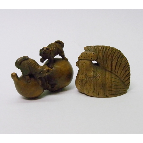 104 - A netsuke depicting two puppies sitting on a gourd, carved fruitwood, signed, 50mm long; a netsuke d... 