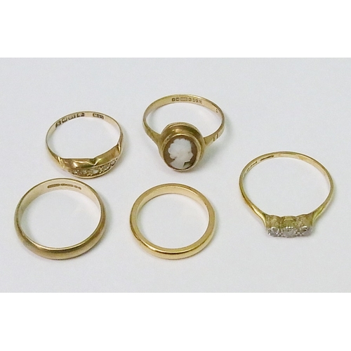 111 - A 22ct gold band ring, 3.5g; a yellow metal diamond trilogy ring; an 18ct gold boat head eternity ri... 