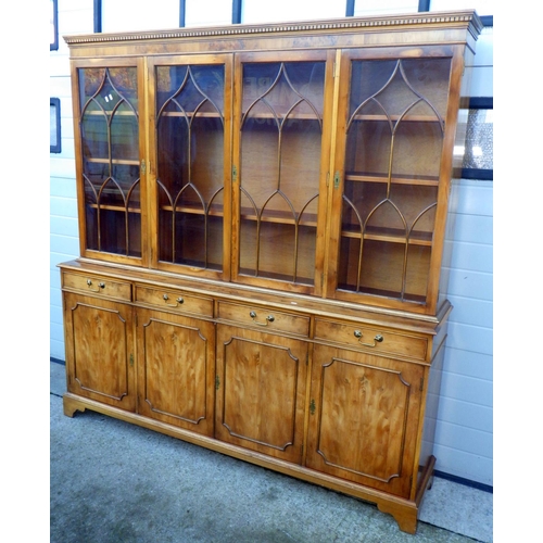 703 - A reproduction yew, four door bookcase, 190cm wide