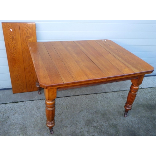 705 - An Edwardian oak wind out dining table with one leaf on reeded legs, together with a set of four Edw... 