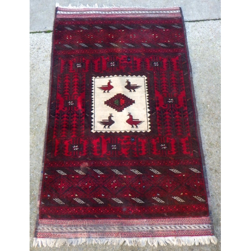 727 - A red ground rug with central birds, 154cm x 90cm